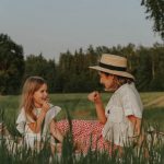 A loving moment shared between mother and daughter during a picnic in a lush field.